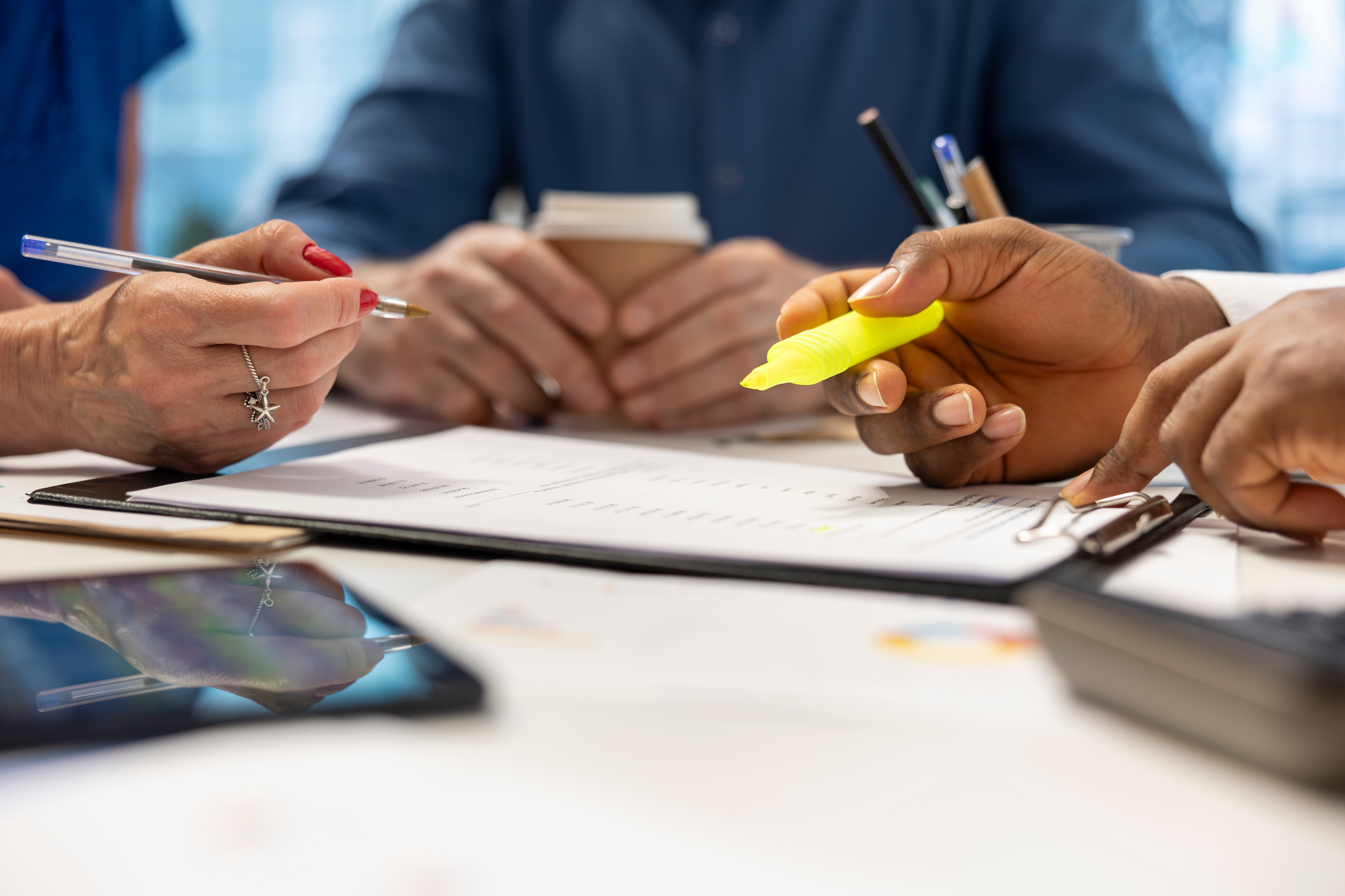 Hands signing documents representing policy change